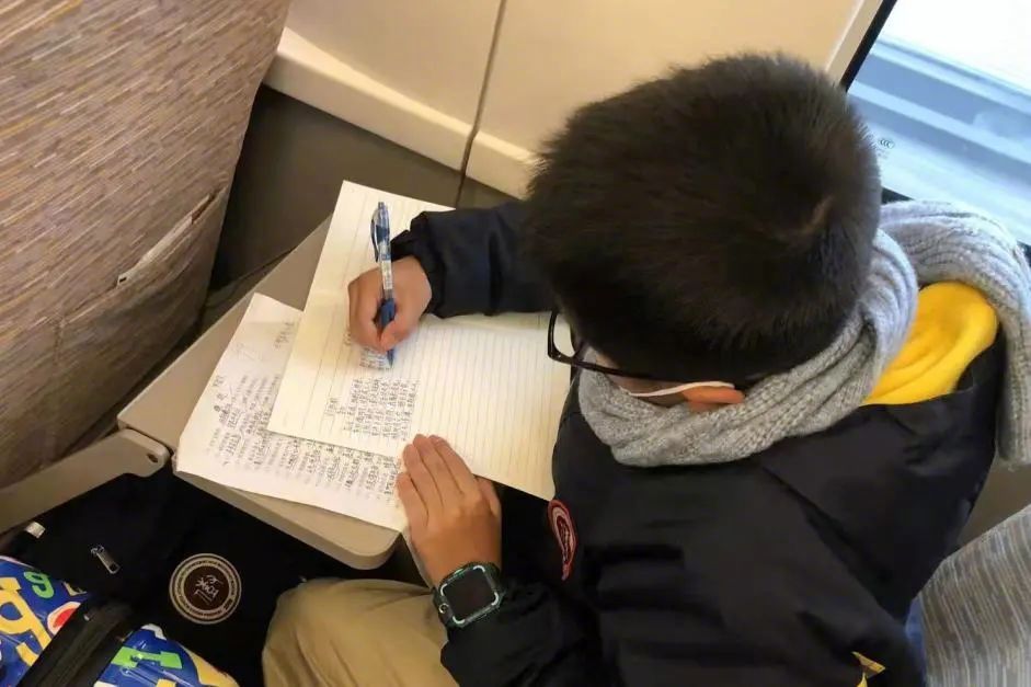 孩子在高铁上写作业