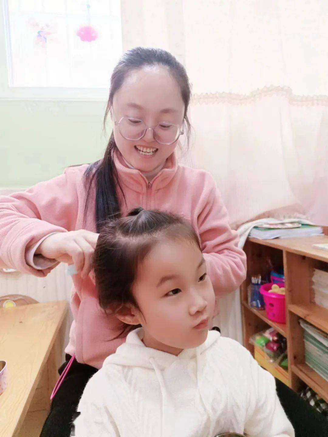 老师帮学生扎头发，师生间的温情互动